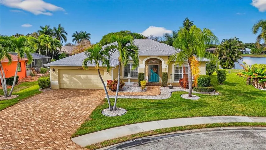 View of front of property with stucco siding, a front lawn, decorative driveway, and an attached garage