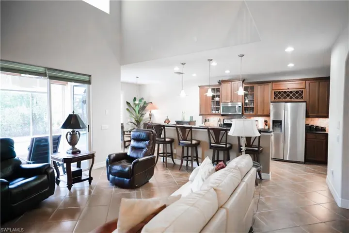 Living room with light tile patterned floors and a towering ceiling