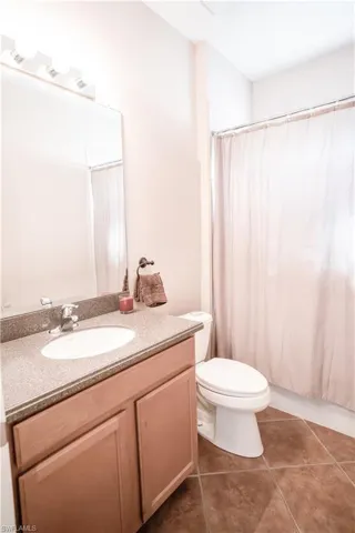 Bathroom with vanity, tile patterned floors, and toilet