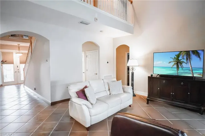 Tiled living room featuring french doors and a high ceiling