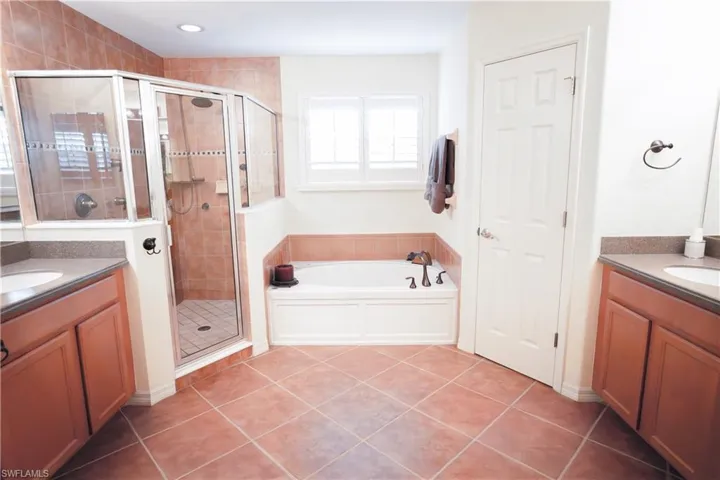 Bathroom featuring plus walk in shower, tile patterned floors, and vanity