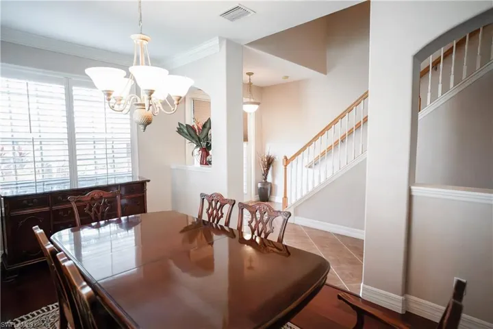 Tiled dining space with ornamental molding and a chandelier