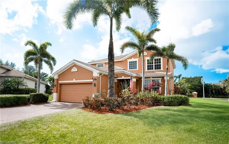 View of front of house with a garage and a front lawn