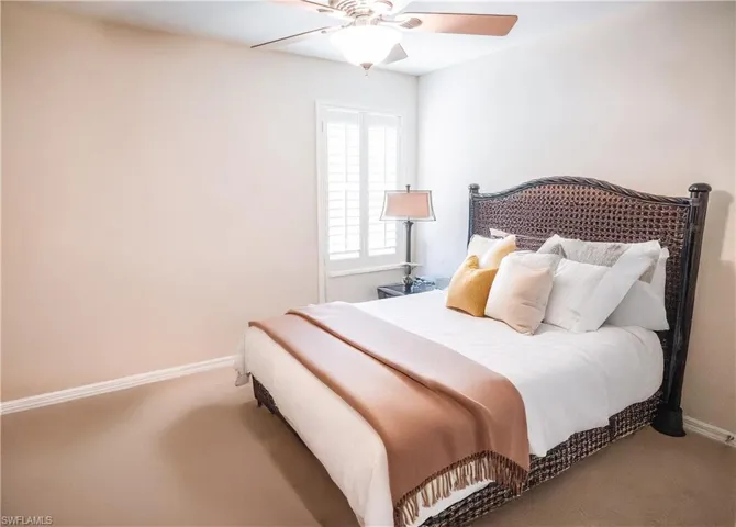 Carpeted bedroom featuring ceiling fan