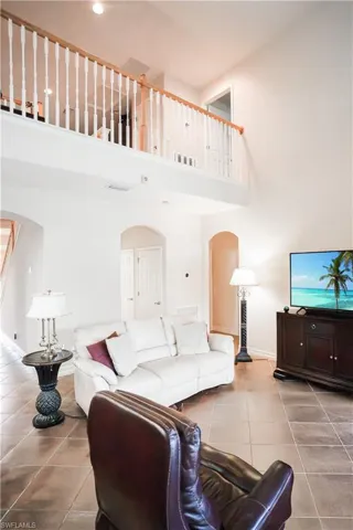 Living room featuring a towering ceiling and tile patterned floors