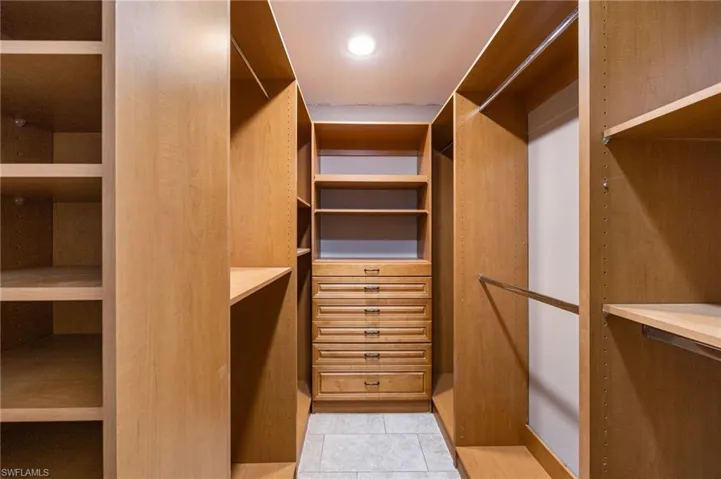 Walk in California closet featuring light tile patterned floors