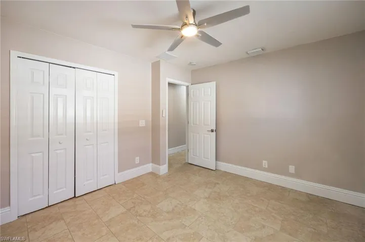 Secondary bedroom featuring a ceiling fan and a closet