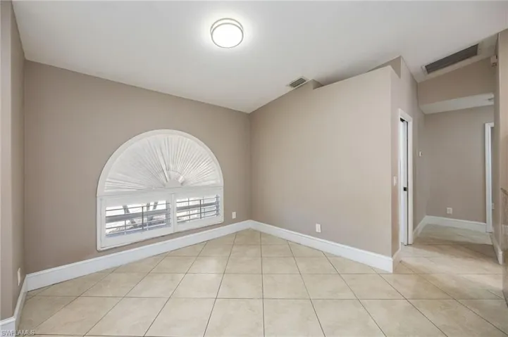 Living room featuring light tile patterned floors and vaulted ceiling