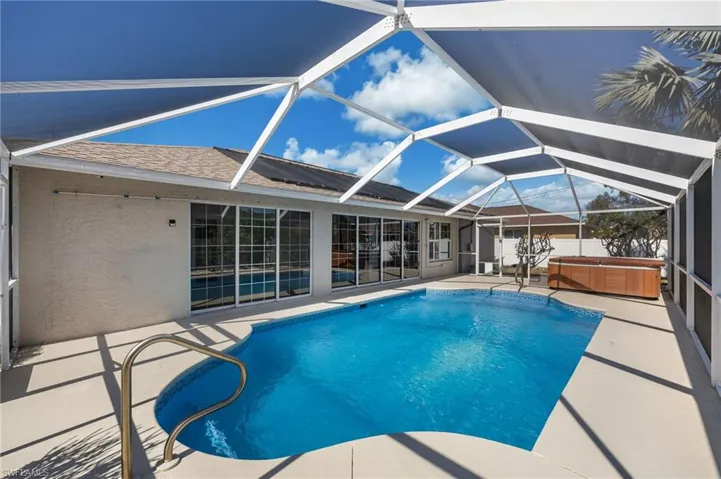 Outdoor pool featuring a hot tub and a lanai