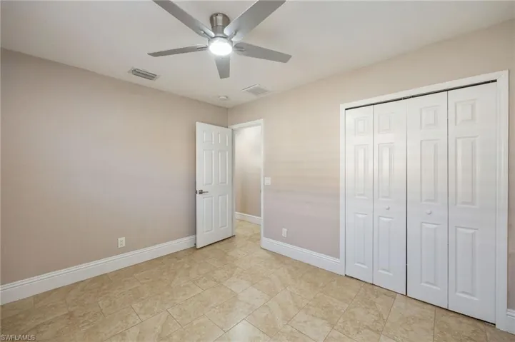 Secondary bedroom featuring a ceiling fan and a closet