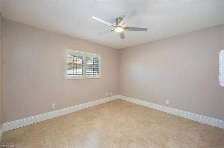 Secondary bedroom with baseboards and ceiling fan