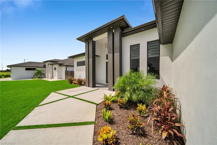 Entrance to property featuring a yard and a patio