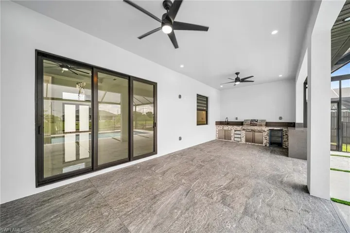 Unfurnished living room featuring ceiling fan, wine cooler, and sink