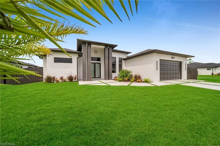 View of front of house with a garage and a front lawn