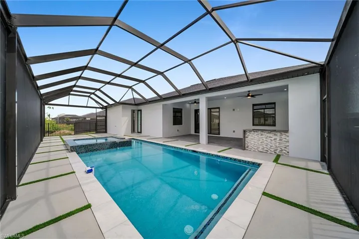 View of swimming pool featuring a lanai, an in ground hot tub, ceiling fan, and a patio