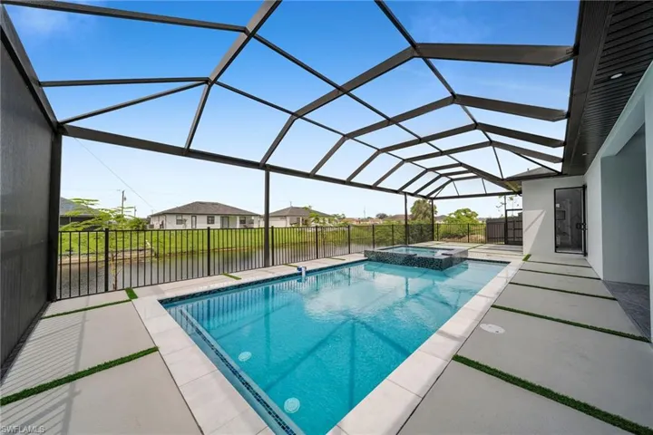 View of swimming pool with a lanai, a patio area, and an in ground hot tub