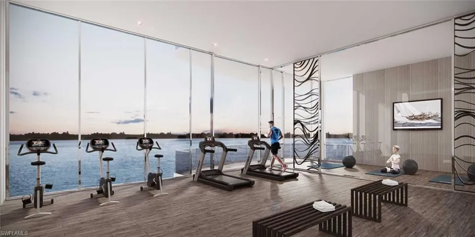 Workout area featuring a water view, hardwood / wood-style floors, and expansive windows