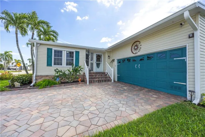 Two-car garage with paver driveway and inviting entry