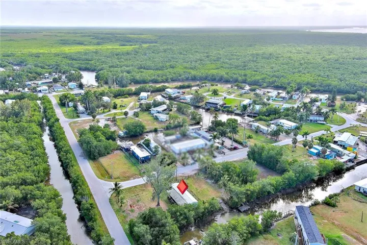 Aerial overview of property's location featuring a heavily wooded area and a large body of water