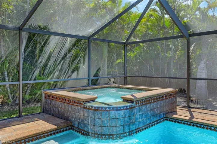 Pool with glass enclosure and an in ground hot tub