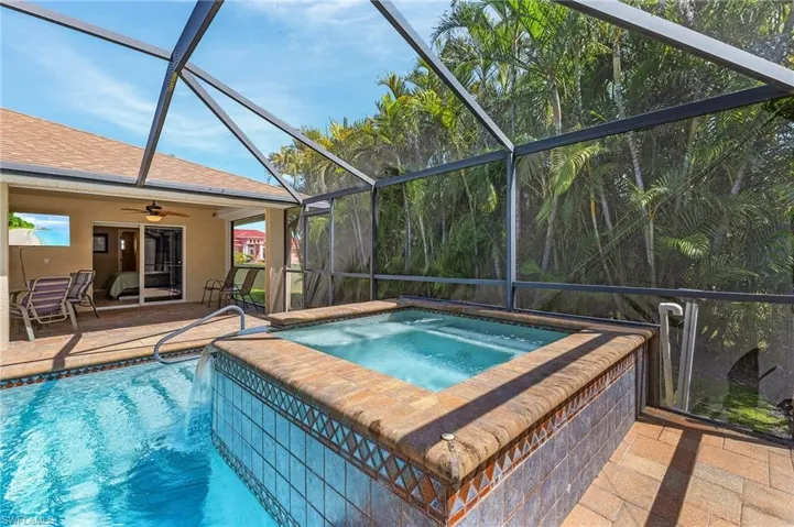 Pool featuring a lanai, an in ground hot tub, a ceiling fan, and a patio