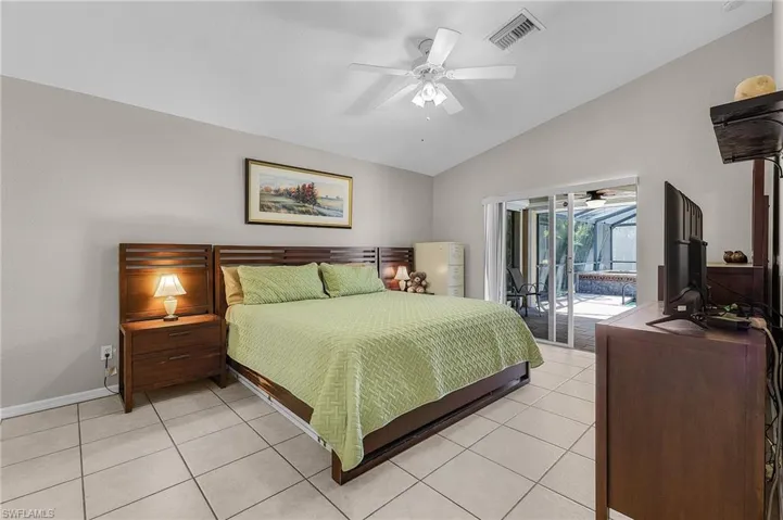 Bedroom featuring visible vents, ceiling fan, vaulted ceiling, light tile patterned floors, and access to outside