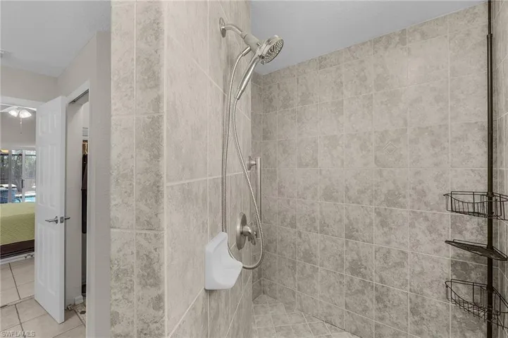 Ensuite bathroom with tile patterned flooring, ensuite bath, and a tile shower