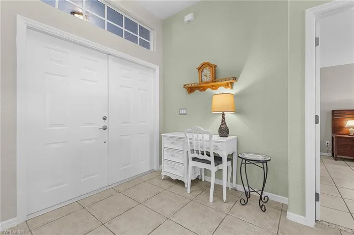 Entryway featuring light tile patterned floors and baseboards