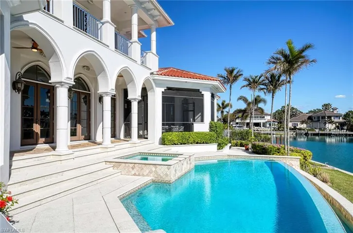 View of swimming pool with a sunroom, french doors, a water view, an in ground hot tub, and a patio