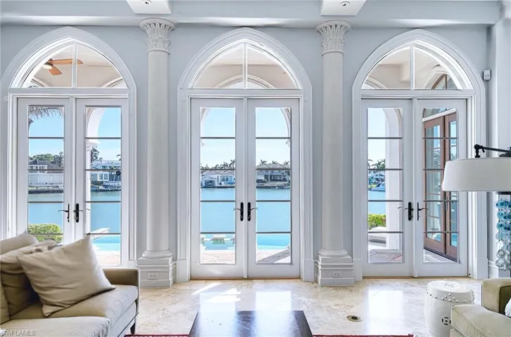 Doorway to outside featuring a water view, decorative columns, and french doors