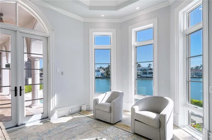 Doorway with a water view, crown molding, and a healthy amount of sunlight