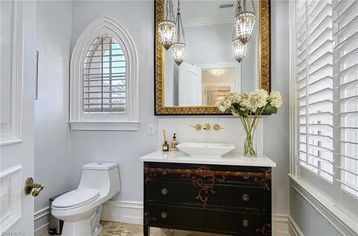 Bathroom with vanity, toilet, and ornamental molding