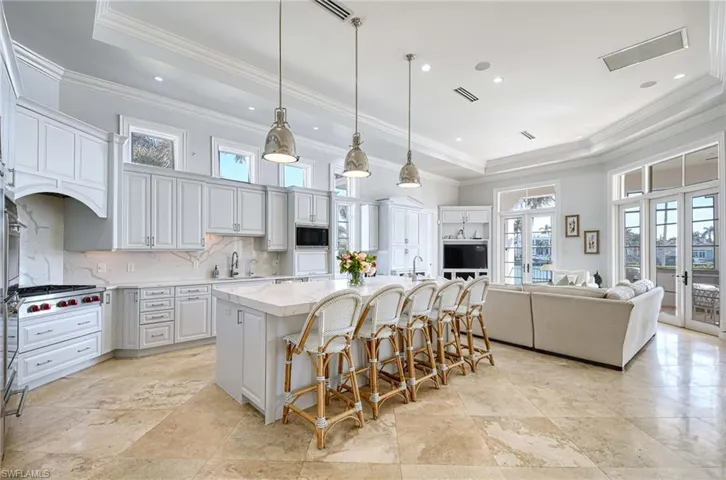 Kitchen featuring plenty of natural light, a kitchen island with sink, and french doors