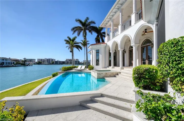 View of pool featuring an in ground hot tub, a water view, and a patio