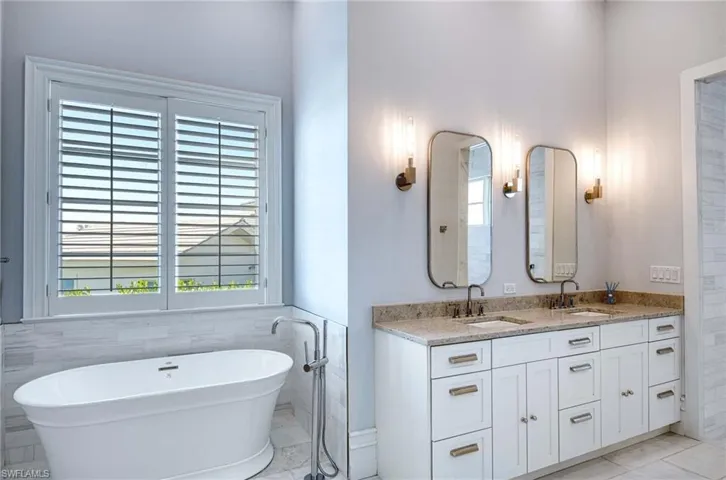 Bathroom featuring a bathtub, tile walls, and vanity