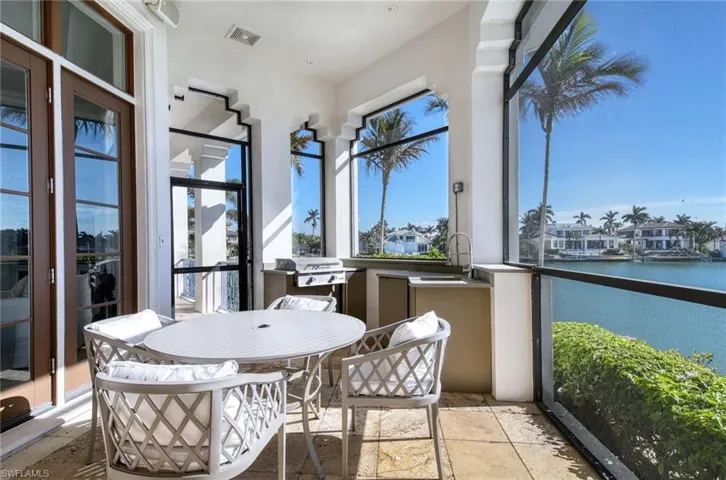 Sunroom / solarium featuring a water view and sink