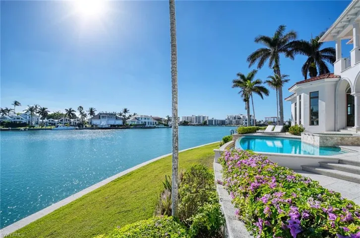 View of swimming pool with a lawn and a water view