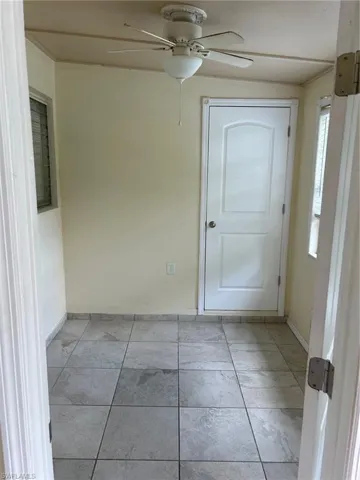 Spare room featuring a ceiling fan, baseboards, and plenty of natural light