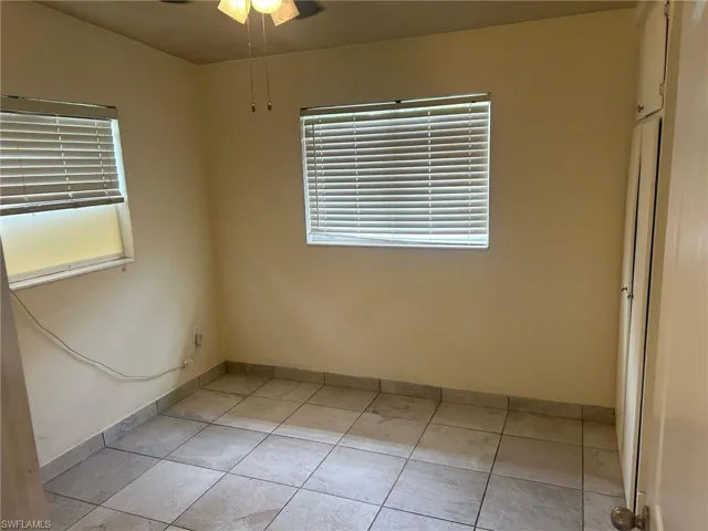 Spare room with plenty of natural light, light tile patterned floors, and a ceiling fan