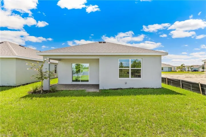 Back of property featuring stucco siding, a patio, and roof with shingles
