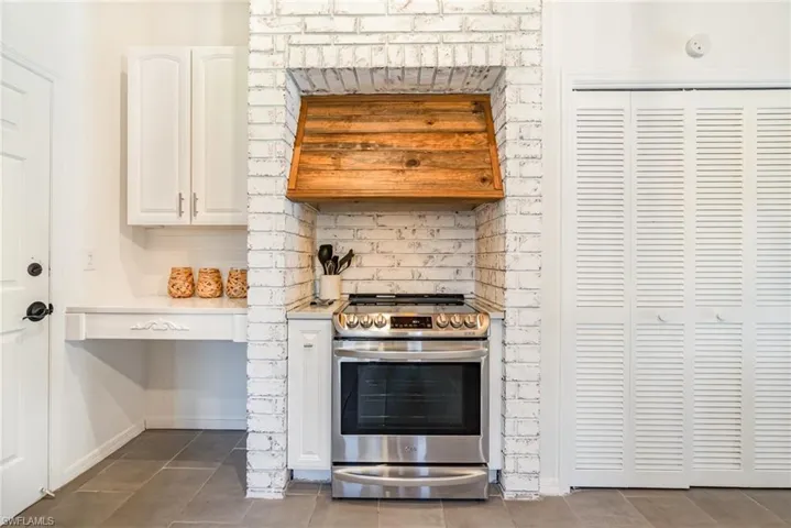 Kitchen featuring range hood and stainless steel electric stove
