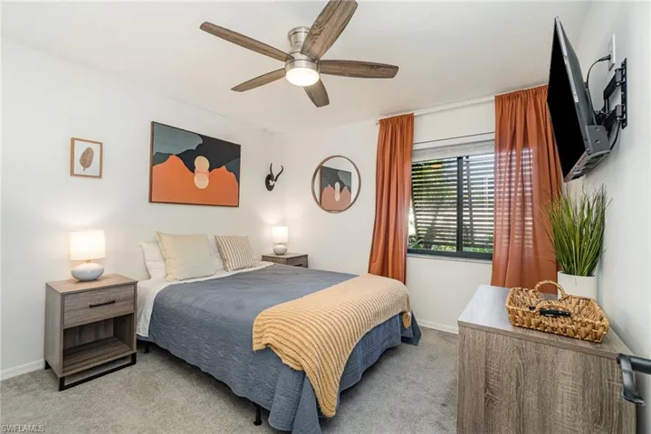 Carpeted third bedroom featuring a large closet with organizers and a ceiling fan