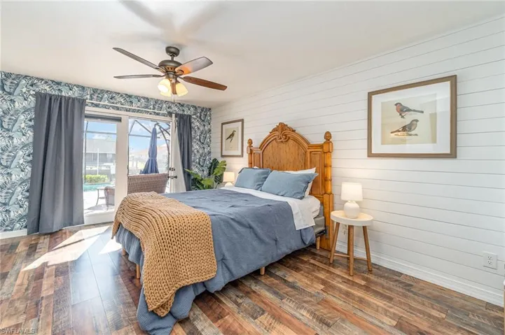 Master bedroom with access to the lanai, ceiling fan, and laminate wood floors