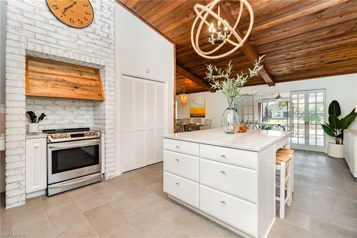 Kitchen featuring wooden ceiling, open shelves, tasteful backsplash, stainless steel appliances, and white cabinets