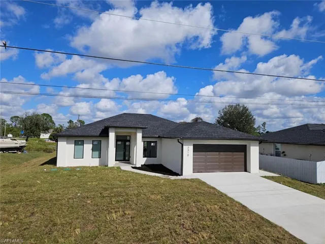 View of front of home featuring a garage and a front yard