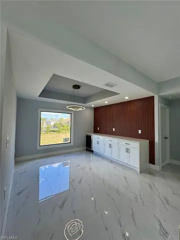 Unfurnished living room featuring a raised ceiling