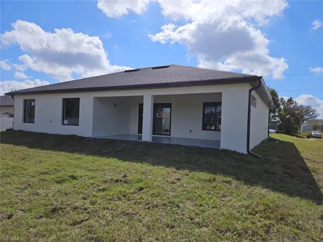 Rear view of property with a patio area and a lawn