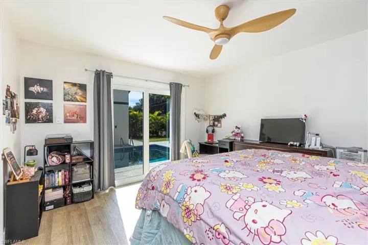 Bedroom featuring access to outside, light wood-type flooring, and ceiling fan
