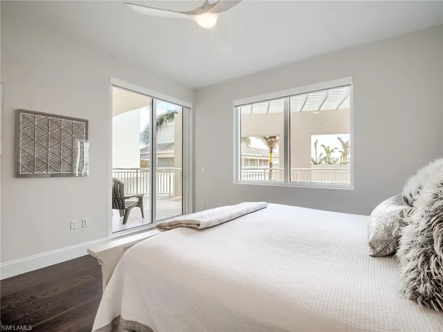 Guest Bedroom 1 featuring access to outside, ceiling fan, and hardwood / wood-style floors