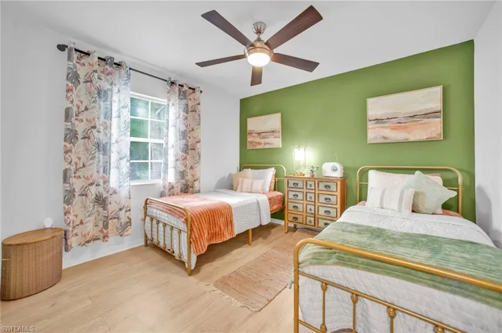 Bedroom with wood finished floors, ceiling fan, and baseboards